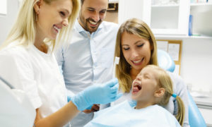 parents and daughter with family dentist